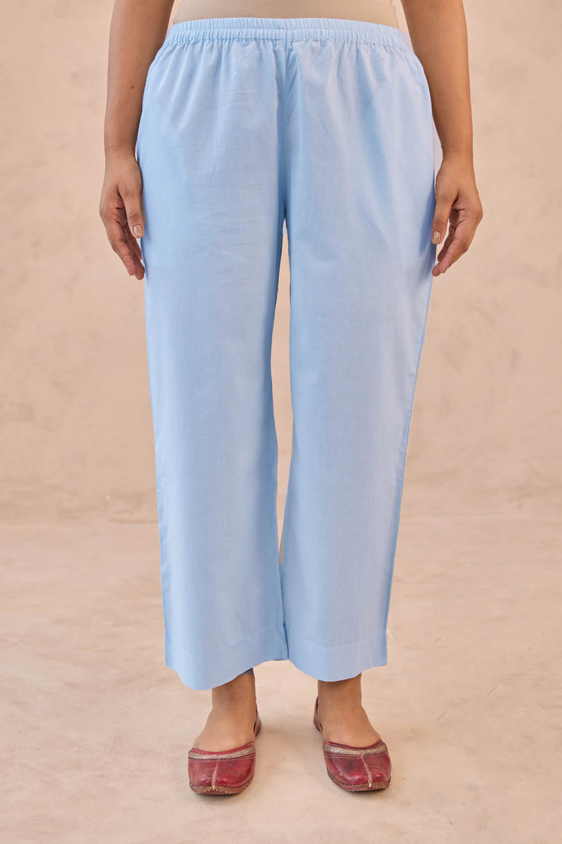 Light blue pants worn by a person on a beige background
